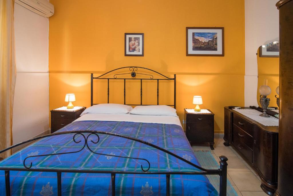 a bedroom with a bed and two night stands and a sink at B&B Casa Paolo in Fiumefreddo di Sicilia