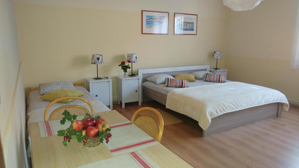 a hotel room with two beds and a table with a table sidx sidx at Apartment Cecilia Koprivnica in Koprivnica