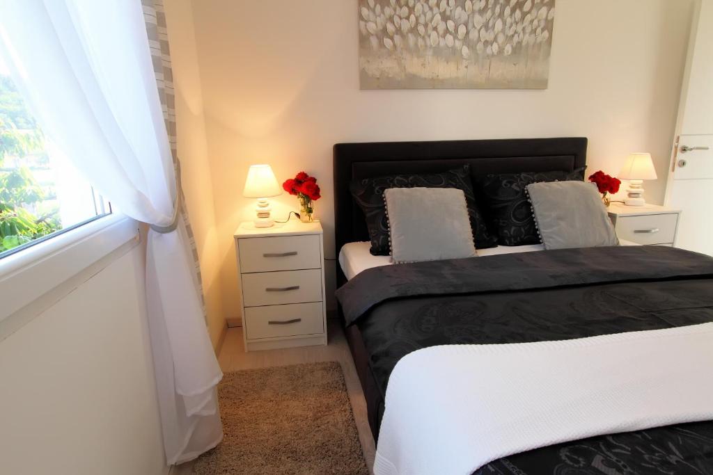 a bedroom with two beds and two lamps and a window at Apartman Ana in Otočac