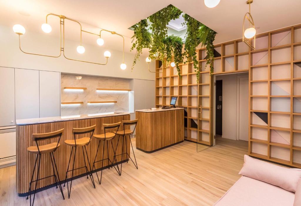 a bar with stools in a room with shelves at Allure Central Boutique Hotel in Lefkada Town