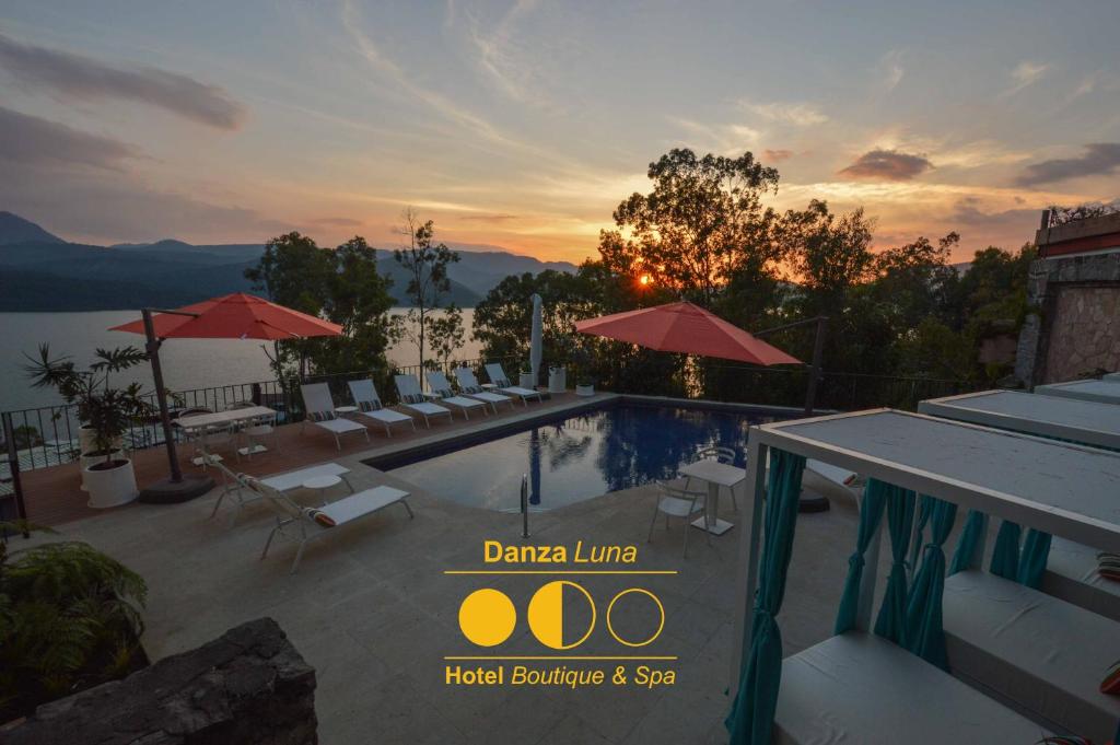 a pool with chairs and umbrellas on a resort at Danzaluna Hotel Boutique in Valle de Bravo