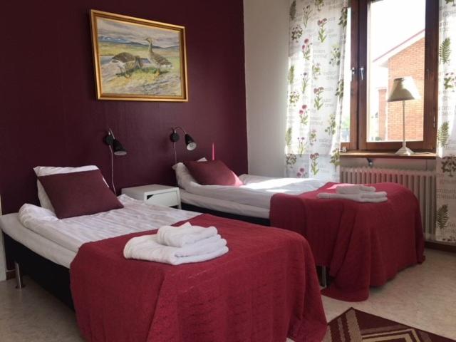 a hotel room with two beds with red sheets at Pensionat Augustin in Gällivare