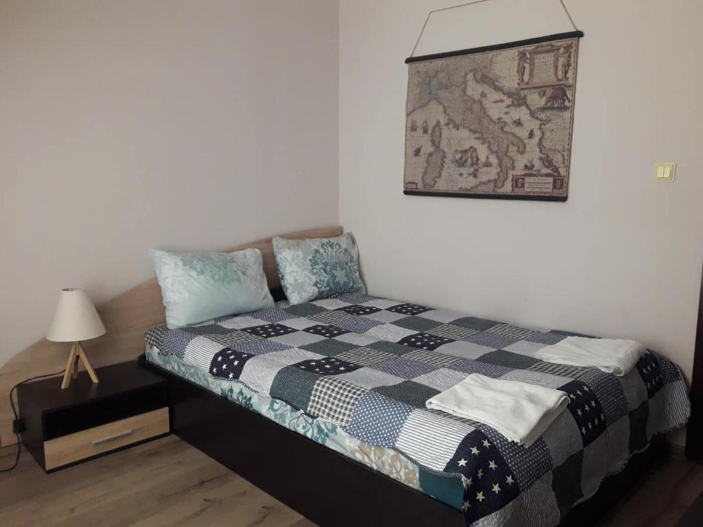 a bedroom with a bed with a quilt on it at Bogorodi Terrace Apartment in Burgas