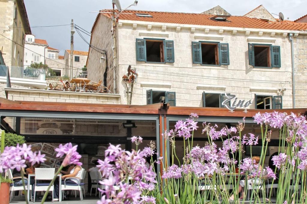 einen Garten mit lila Blumen vor einem Gebäude in der Unterkunft Apartments Seafront in Cavtat