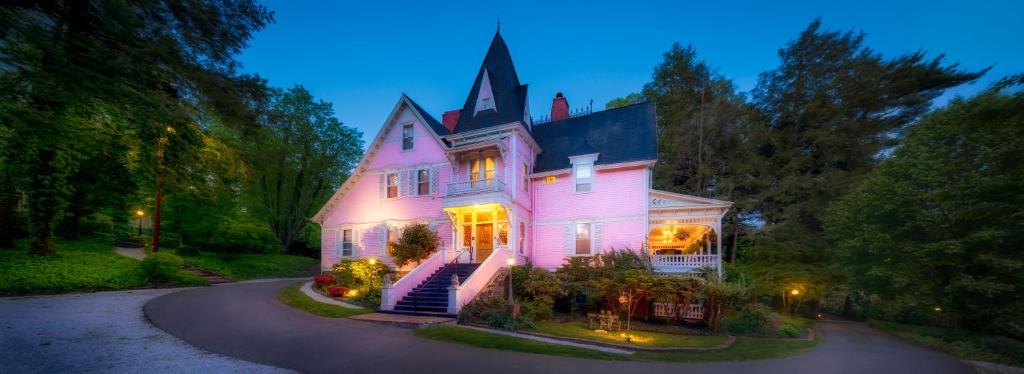 a large pink house with lights on it at Cedar Crest Inn in Asheville