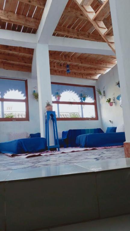 a room with blue chairs and windows at Hostal La Joya in Chefchaouene