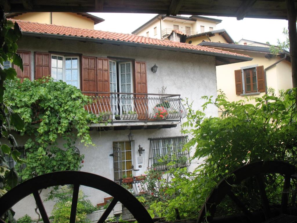 Casa blanca con balcón y árboles en "LA TAVERNA" B&B, en Airuno