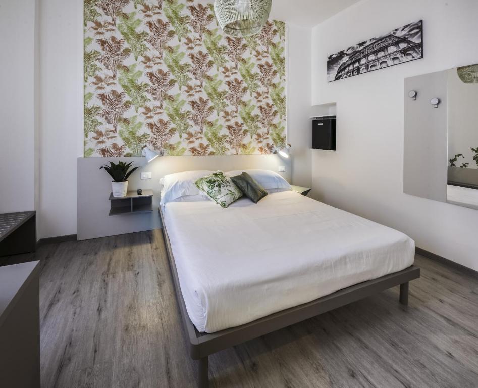 a bedroom with a bed with white sheets and a floral curtain at Lele Rooms San Lorenzo in Rome