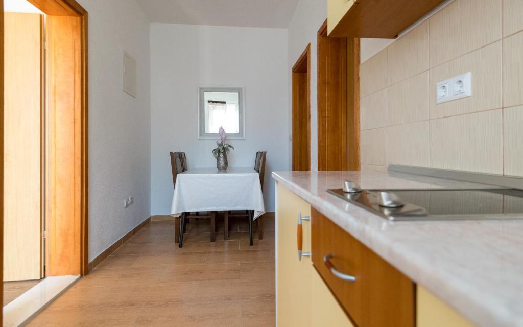 uma cozinha com uma mesa com uma toalha de mesa branca em Tea Apartman em Neum