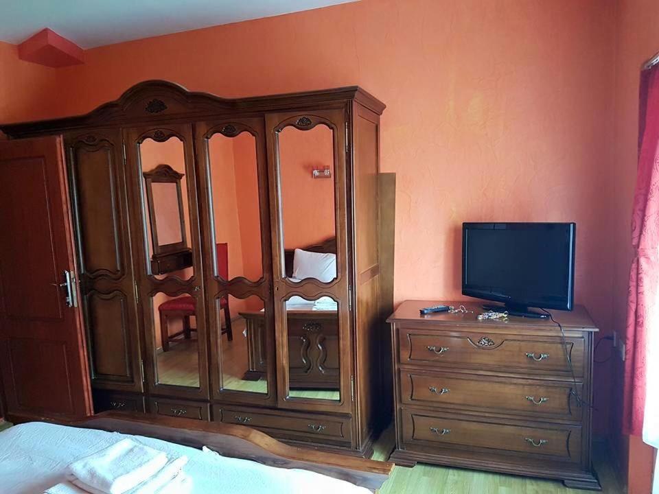 a bedroom with a dresser and a dresser with a tv at Pensiunea Balea in Cîmpeni