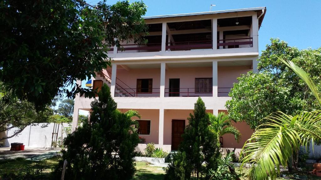 a white building with trees in front of it at Pousadinha Mangabeiras Familia e Grupos in Guriri