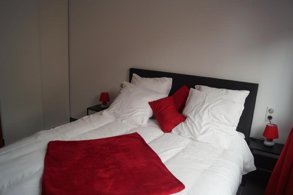 a large white bed with a red blanket on it at Gite du Rocher in Hazelbourg