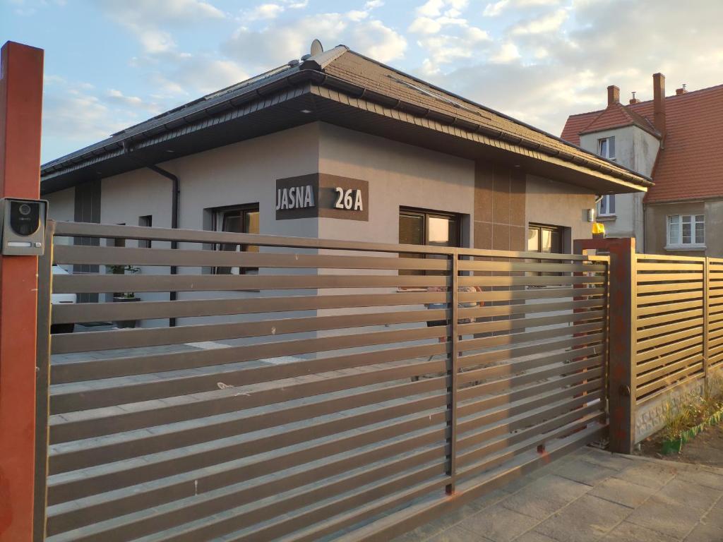 a house with a fence in front of it at Pokoje na Jasnej in Kołobrzeg