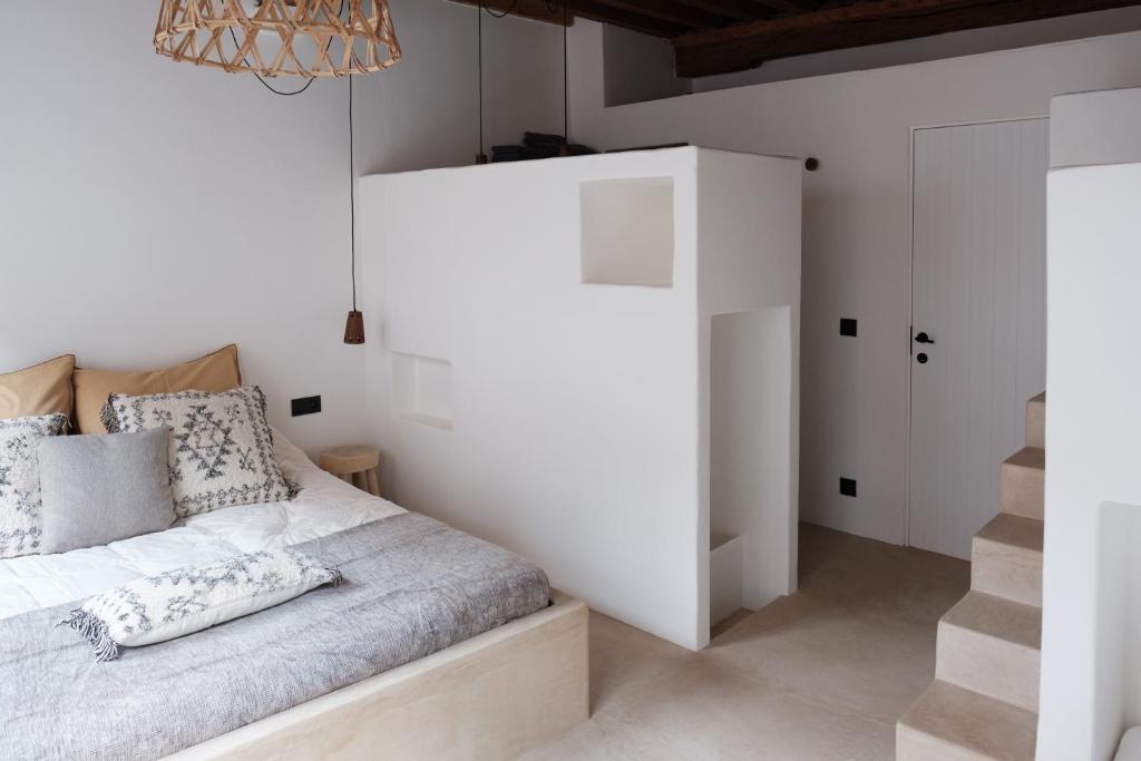 a white bedroom with a bed and a staircase at Boutique Holiday Home ZaligInAntwerpen 77 in Antwerp