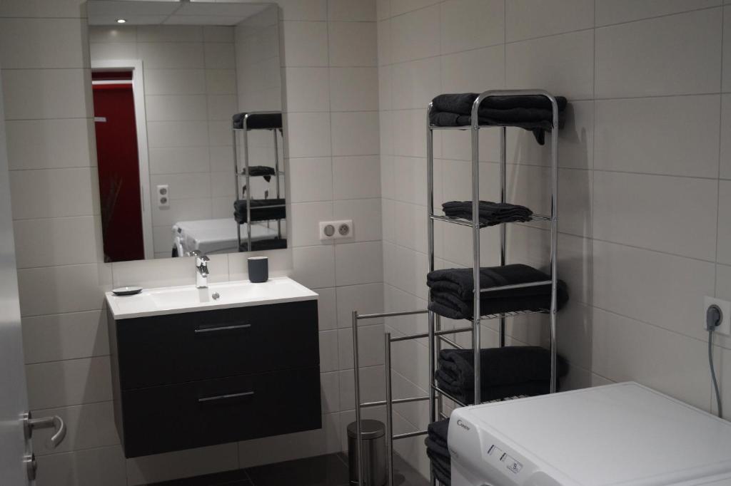 a bathroom with a sink and a mirror and towels at La Schleif in Hazelbourg