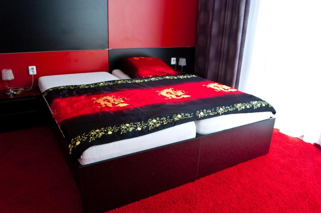ein rotes Schlafzimmer mit einem Bett mit einer roten Decke in der Unterkunft Penzion Best in Moravská Třebová