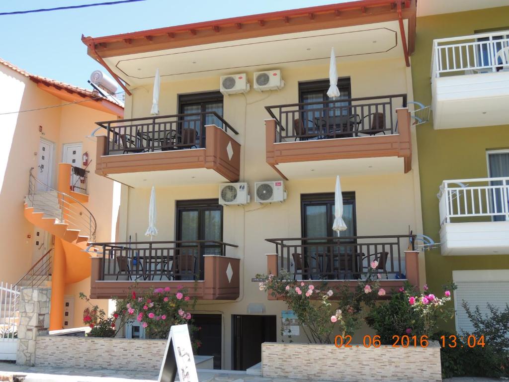 a building with balconies and flowers on it at Malamatenia House in Sarti