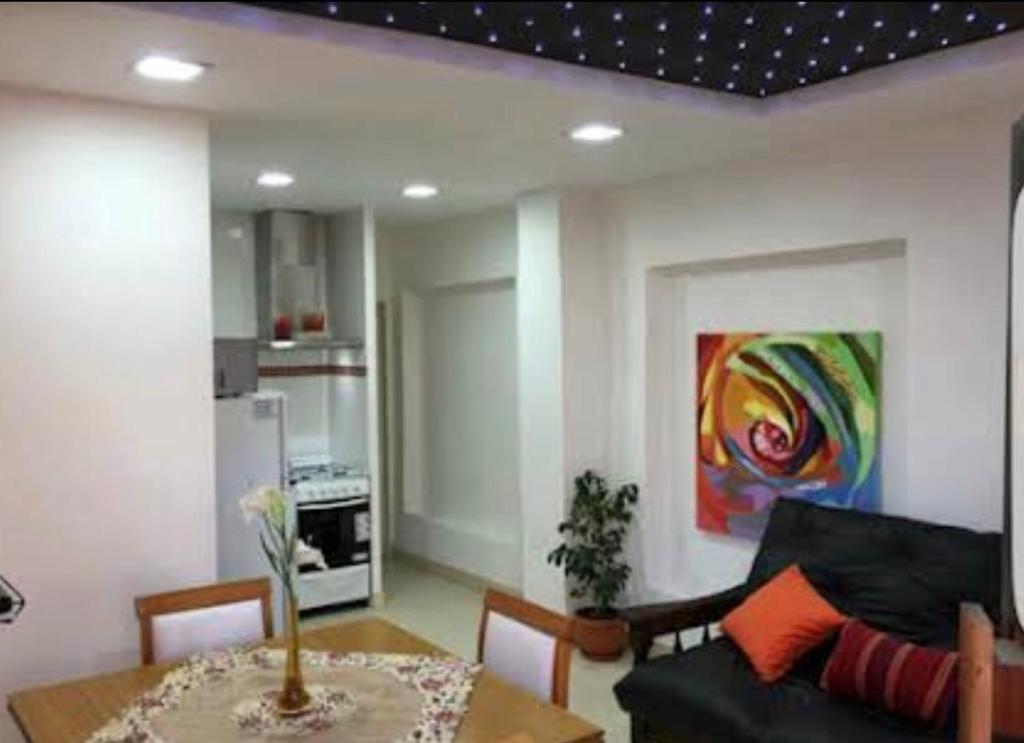 sala de estar con sofá negro y mesa en Apartamento Entre Olivos en Mendoza