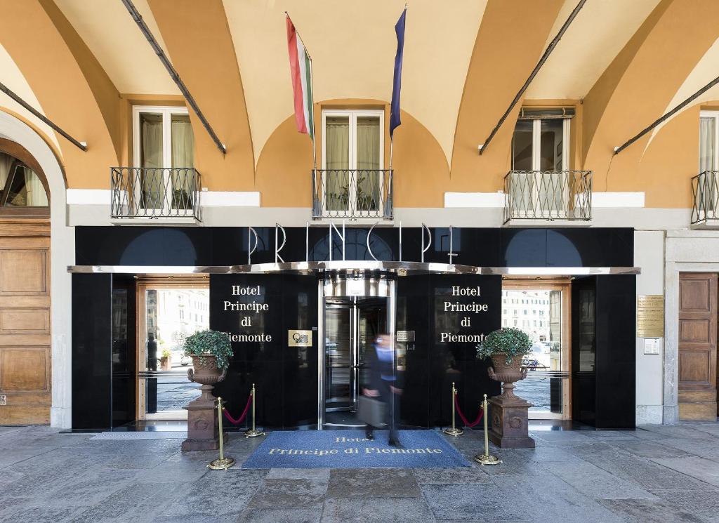 frontowe wejście do budynku z roślinami przed nim w obiekcie Phi Hotel Principe w mieście Cuneo