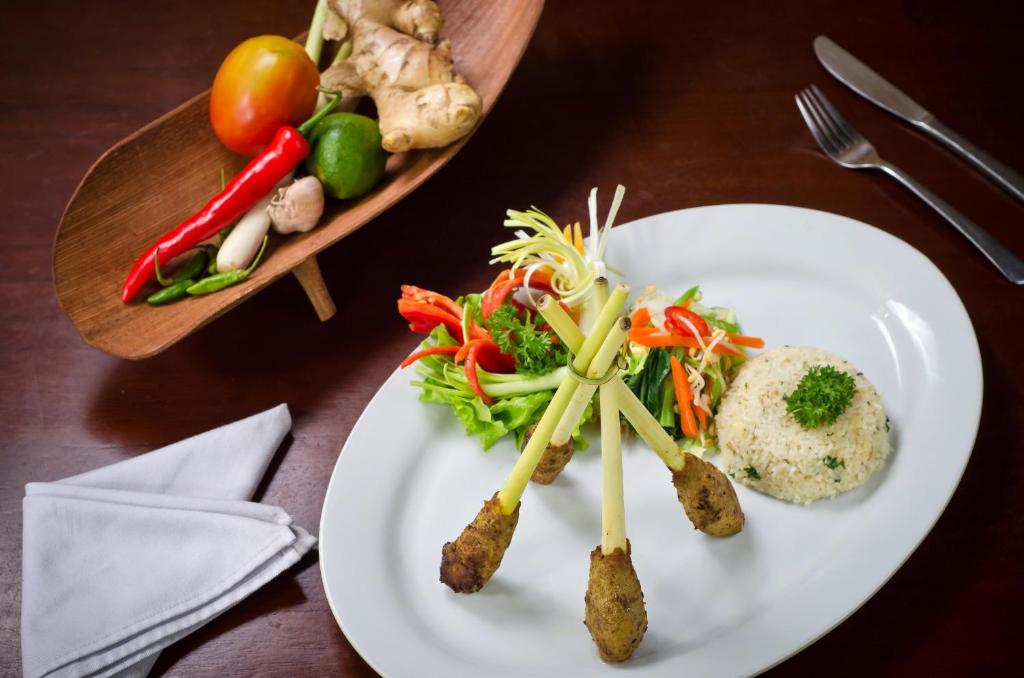 a plate of food with vegetables on a table at Sri Phala Resort & Villa in Sanur