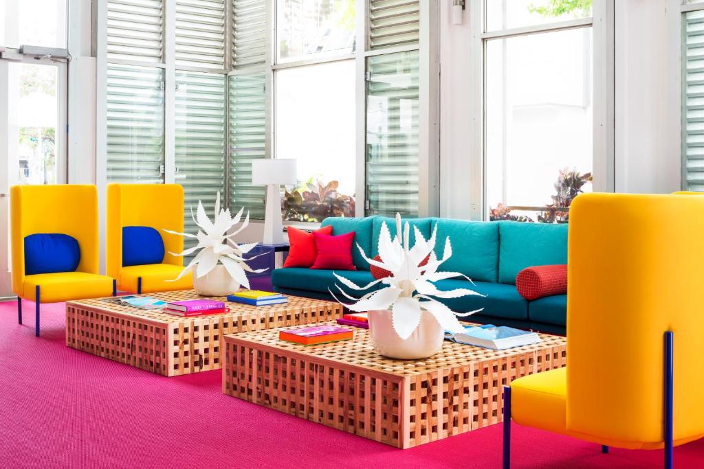 a living room with yellow chairs and a blue couch at Shoreline Hotel Waikiki in Honolulu