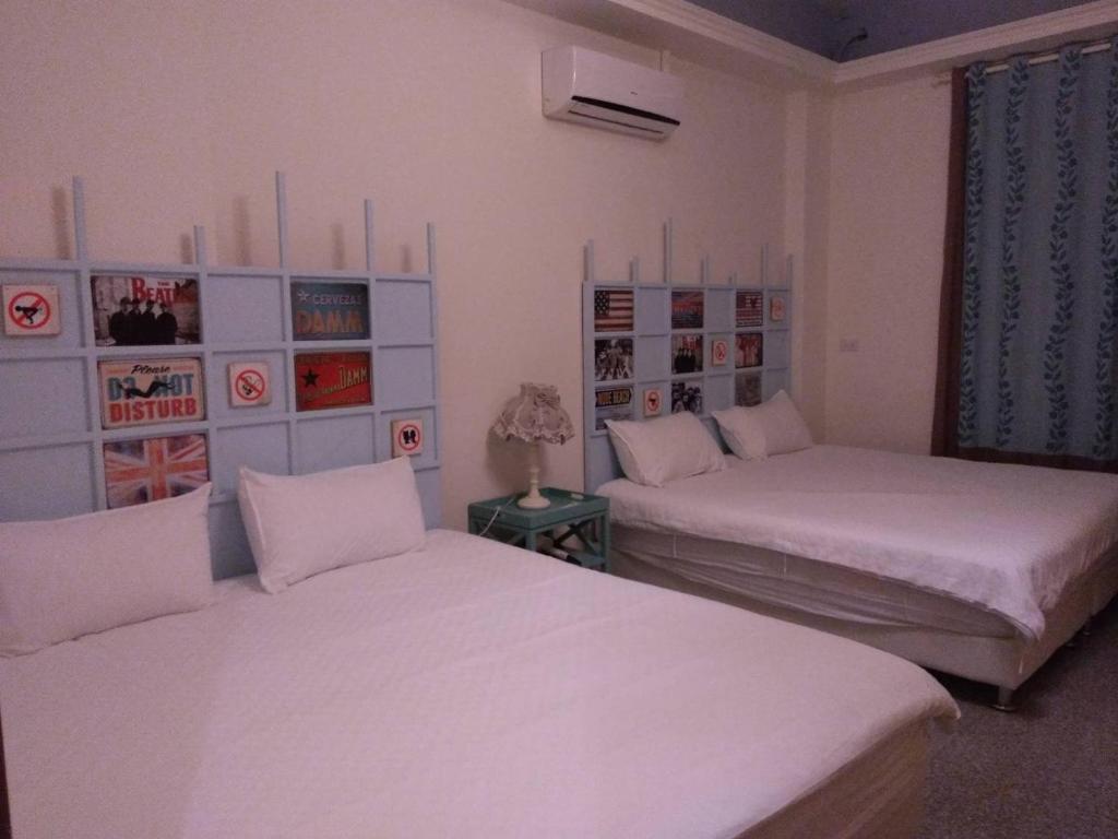 um quarto com duas camas e um sofá em Grapefruit Heping Guesthouse em Hualien