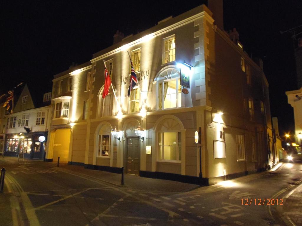 a lit up building on a street at night at Fountain Inn by Greene King Inns in Cowes