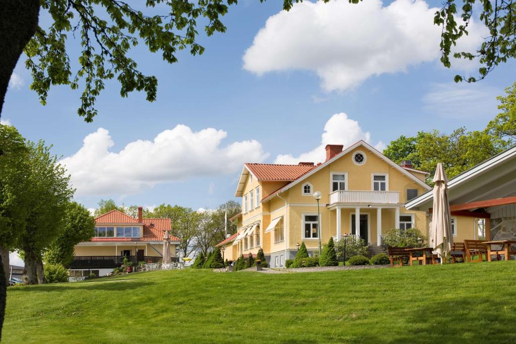 uma grande casa amarela com um relvado verde em Sure Hotel by Best Western Ojaby Herrgard em Växjö