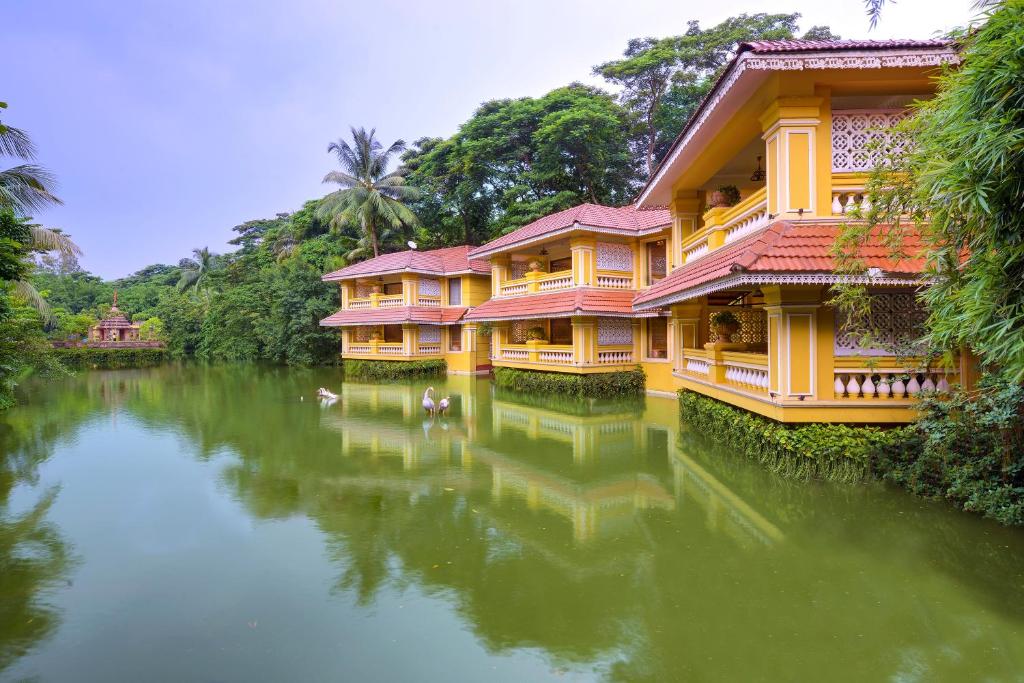 a row of houses on a river with trees at Mayfair Lagoon in Bhubaneshwar