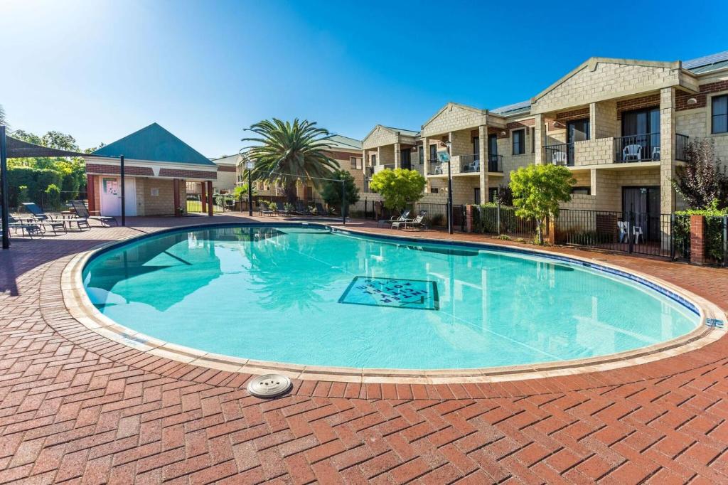 ein großer Pool mit einem Backsteingang um ihn herum in der Unterkunft Country Comfort Perth in Perth