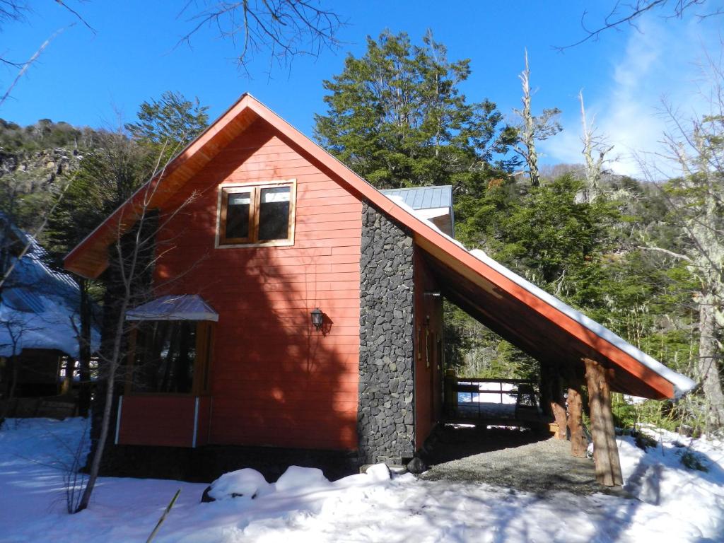 a red barn with snow on the ground at Turismo Shangrila - cabañas in Nevados de Chillan