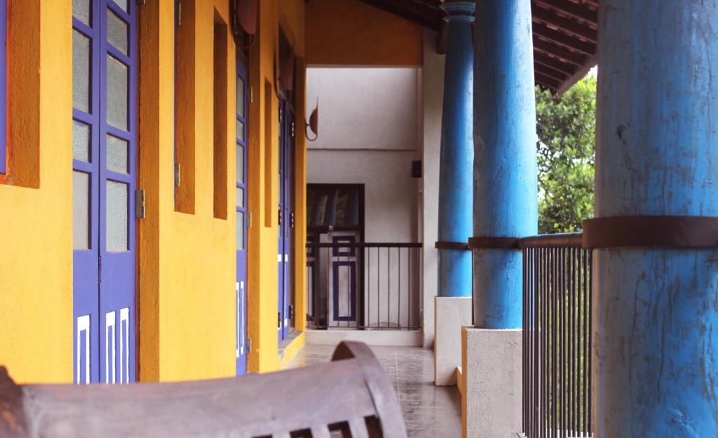 a bench sitting outside of a building with blue columns at Blue Pillars Kandy in Kandy