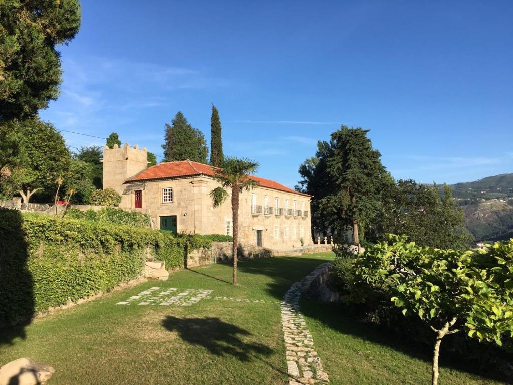 uma antiga casa de pedra com uma palmeira no quintal em Quinta de Águia - Non-Smoking Property em São Lourenço do Douro