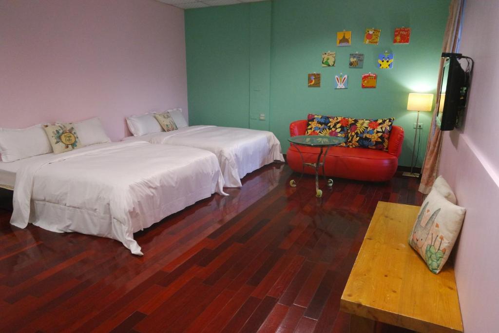 a room with two beds and a couch and a television at Pottery B&amp;B in Jiaoxi