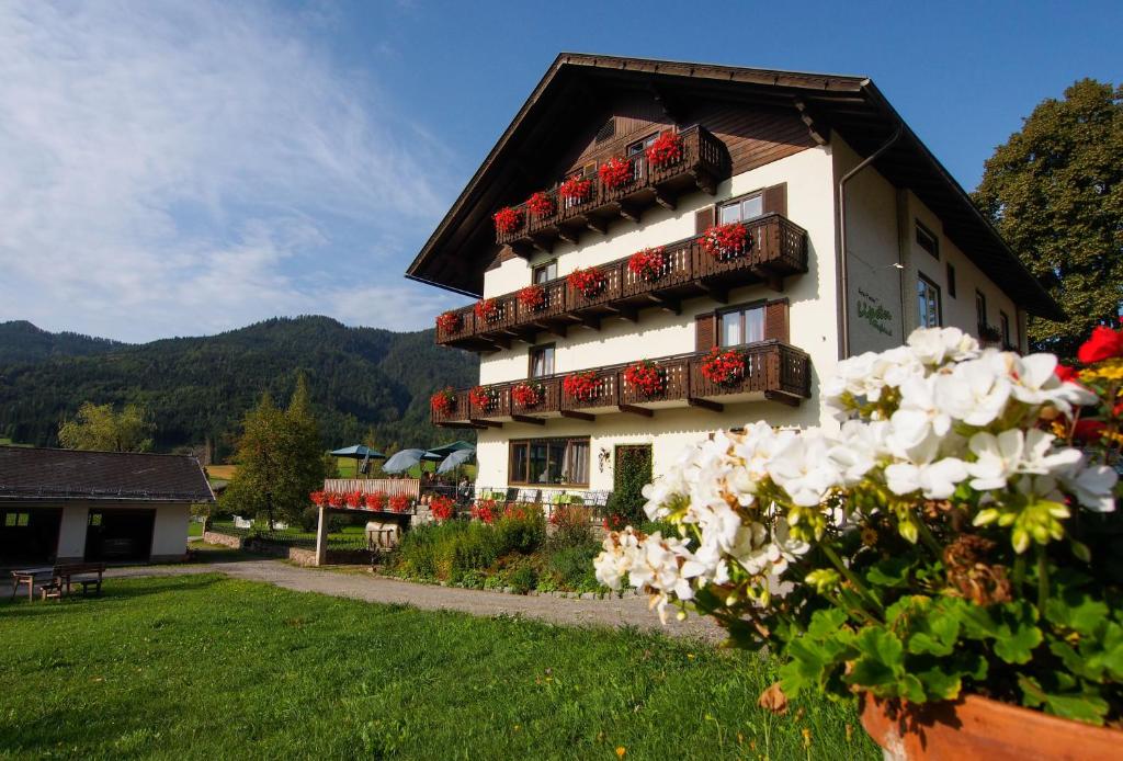 a building with a bunch of flower boxes on it at Hotel Lipeter & Bergheimat in Weissensee