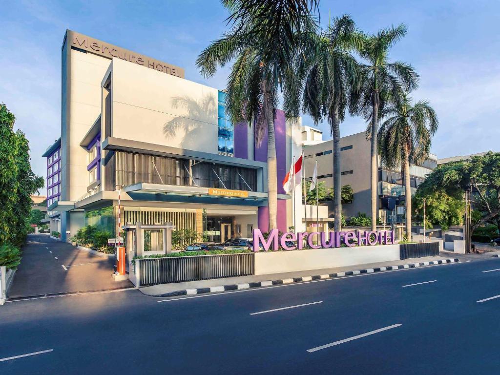 a building with a sign on the side of a street at Mercure Jakarta Cikini in Jakarta