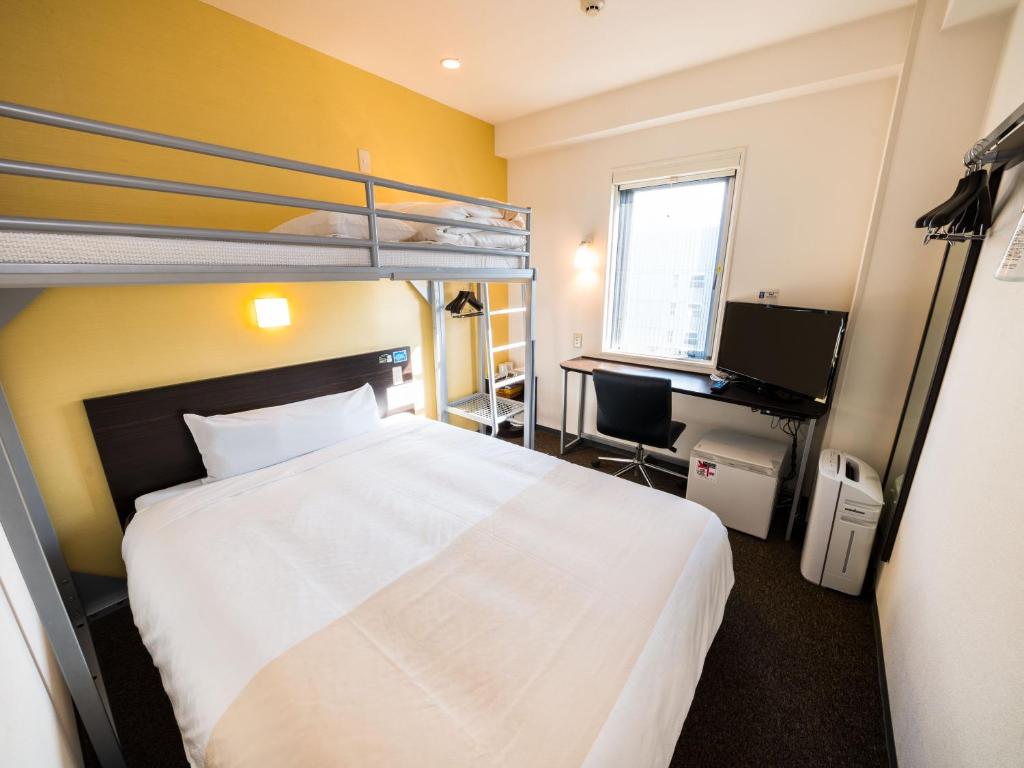 מיטה או מיטות קומותיים בחדר ב-Super Hotel Niihama