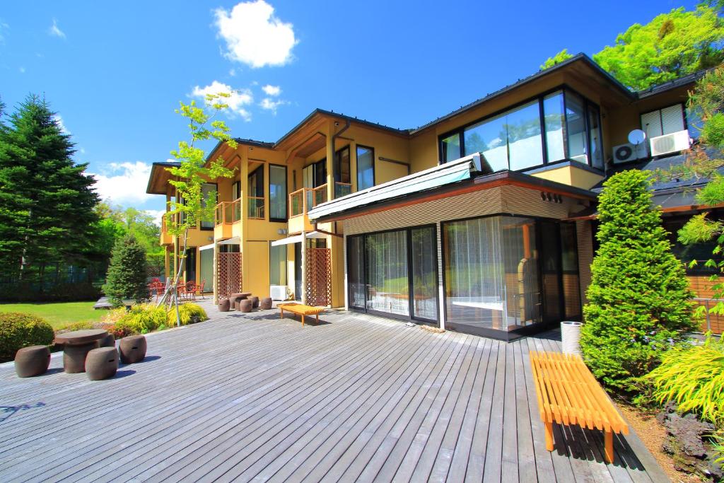 a large house with a large deck in front of it at Hatago Tsubakiya in Yamanakako