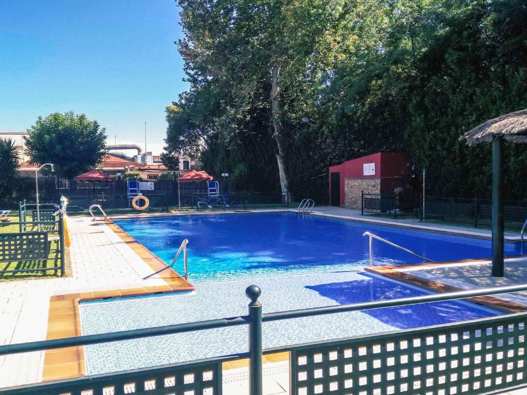 a large blue swimming pool with a playground at Hotel Rio Badajoz in Badajoz