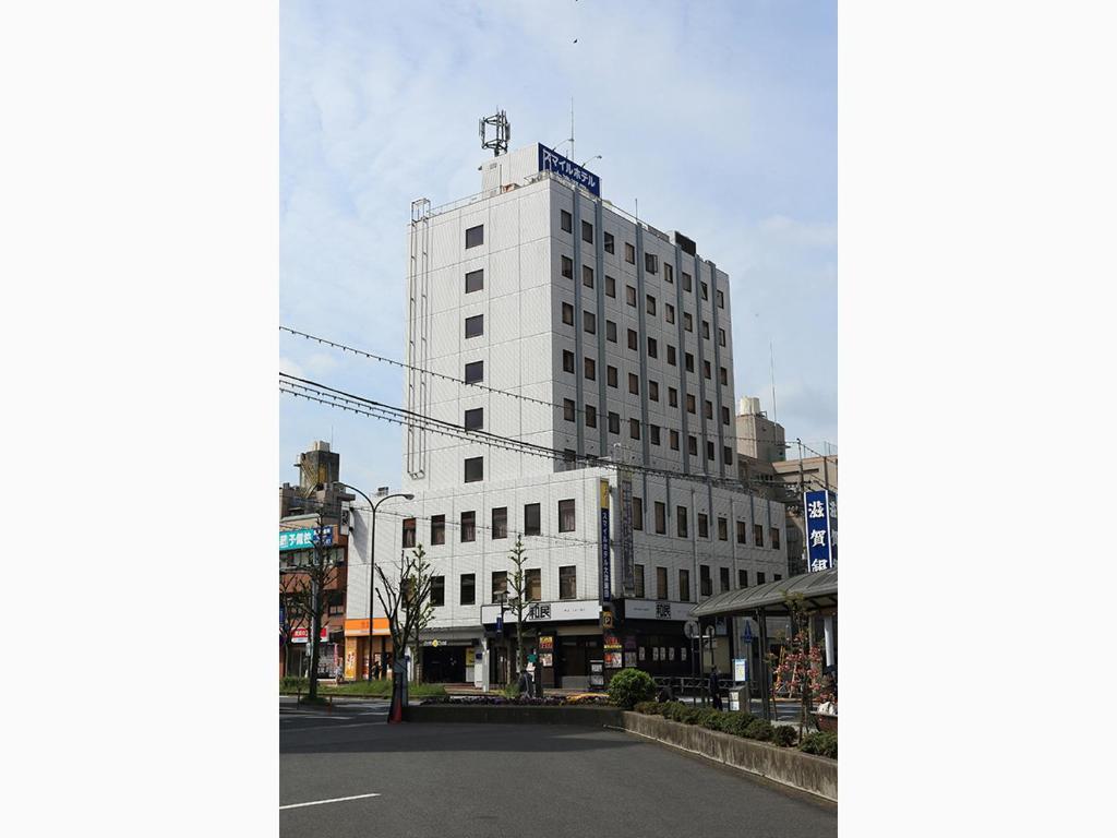 大津大津濑田微笑酒店的上面有蓝色标志的白色建筑