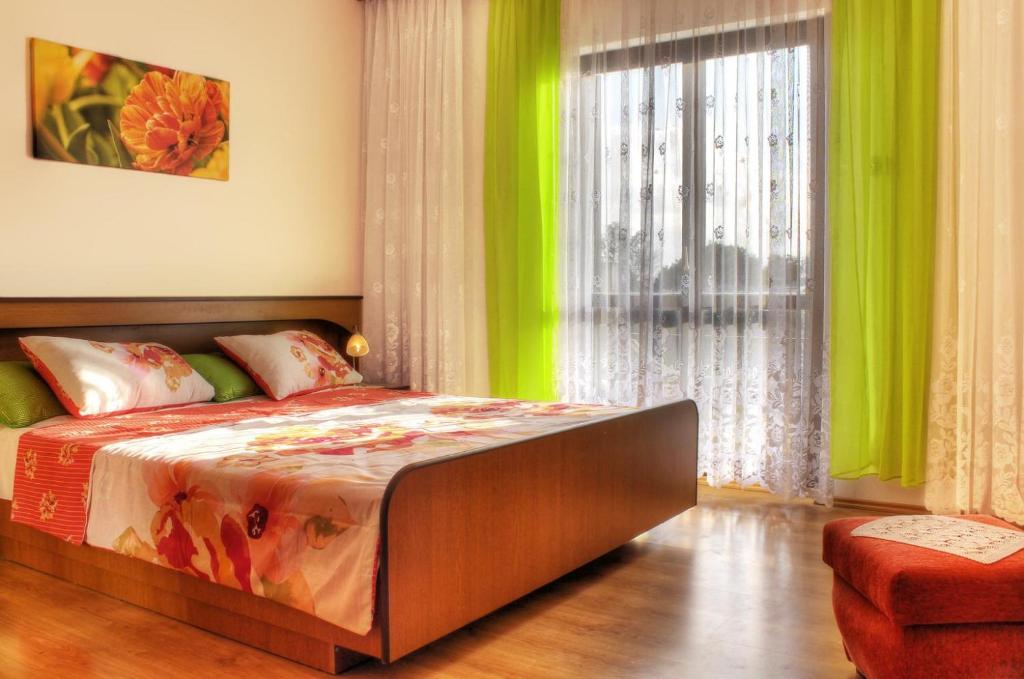 a bedroom with a large bed with green curtains at Haus Natur Apartment in Šišan