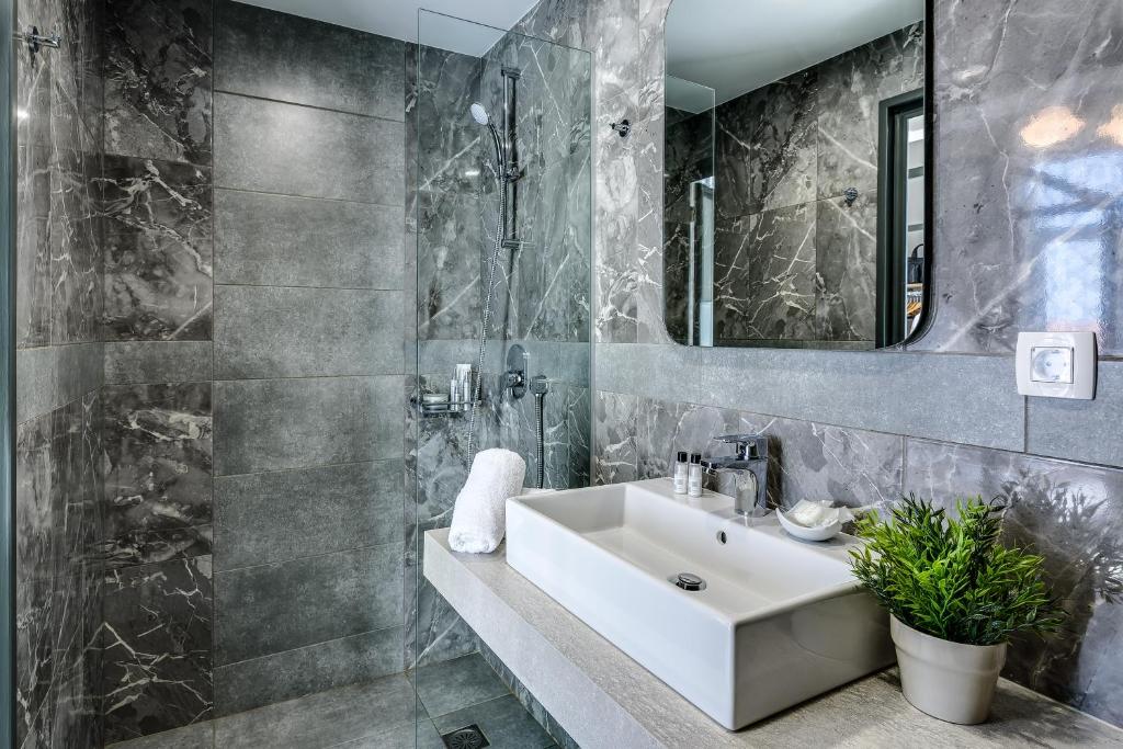 een badkamer met een wastafel en een spiegel bij Mosaic in Chania