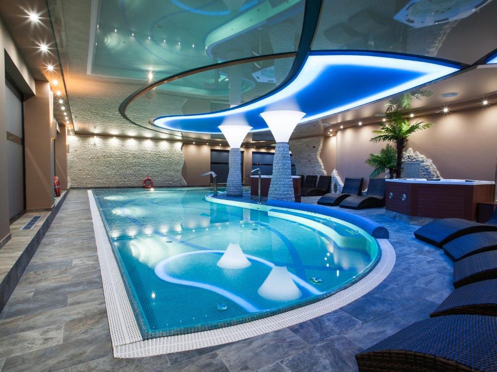 a swimming pool in a hotel lobby with a blue ceiling at Hotel Zawiercie in Zawiercie