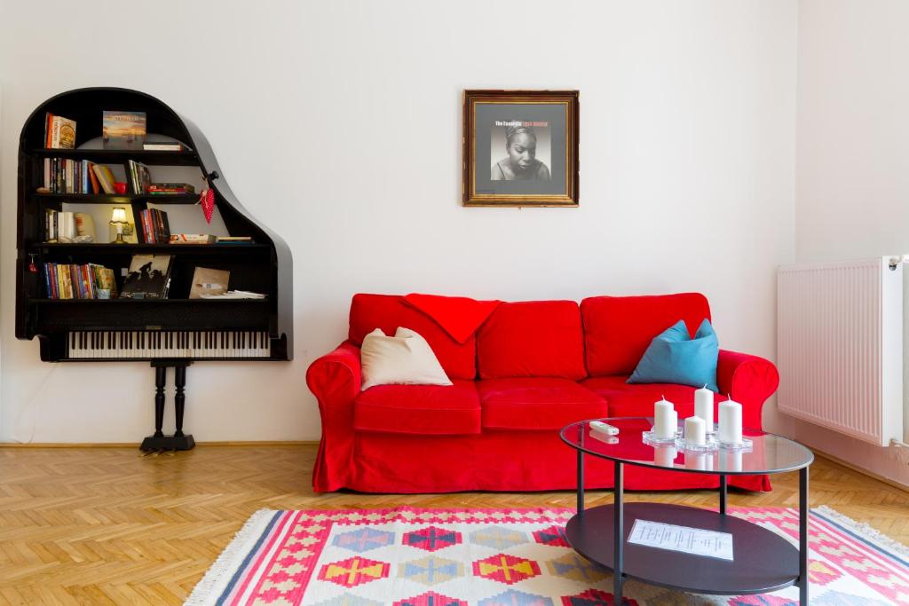 ブダペストにあるRubinstein Relax Apartmanのリビングルーム(赤いソファ、テーブル付)