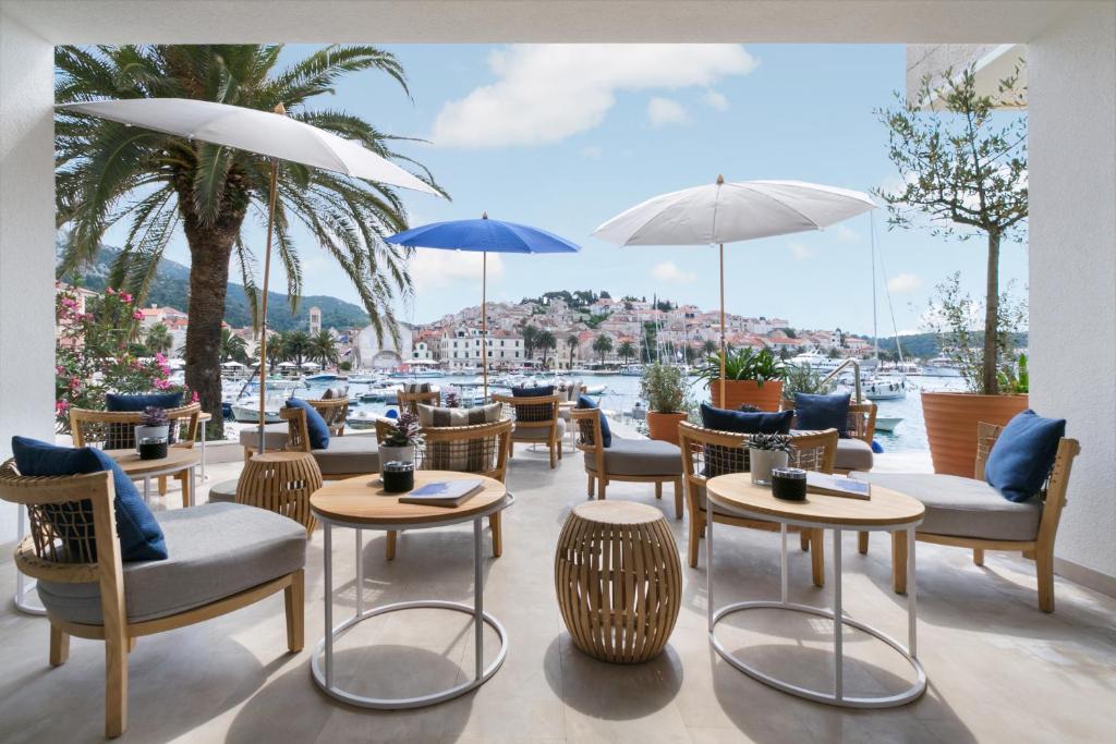 un restaurante con sillas, mesas y sombrillas en Adriana Hvar Spa Hotel, en Hvar