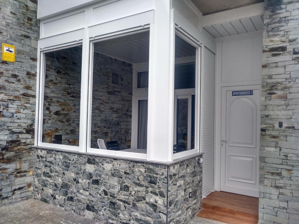 a window on a house with a stone wall at Apartamentos turísticos Vistademar in Luarca