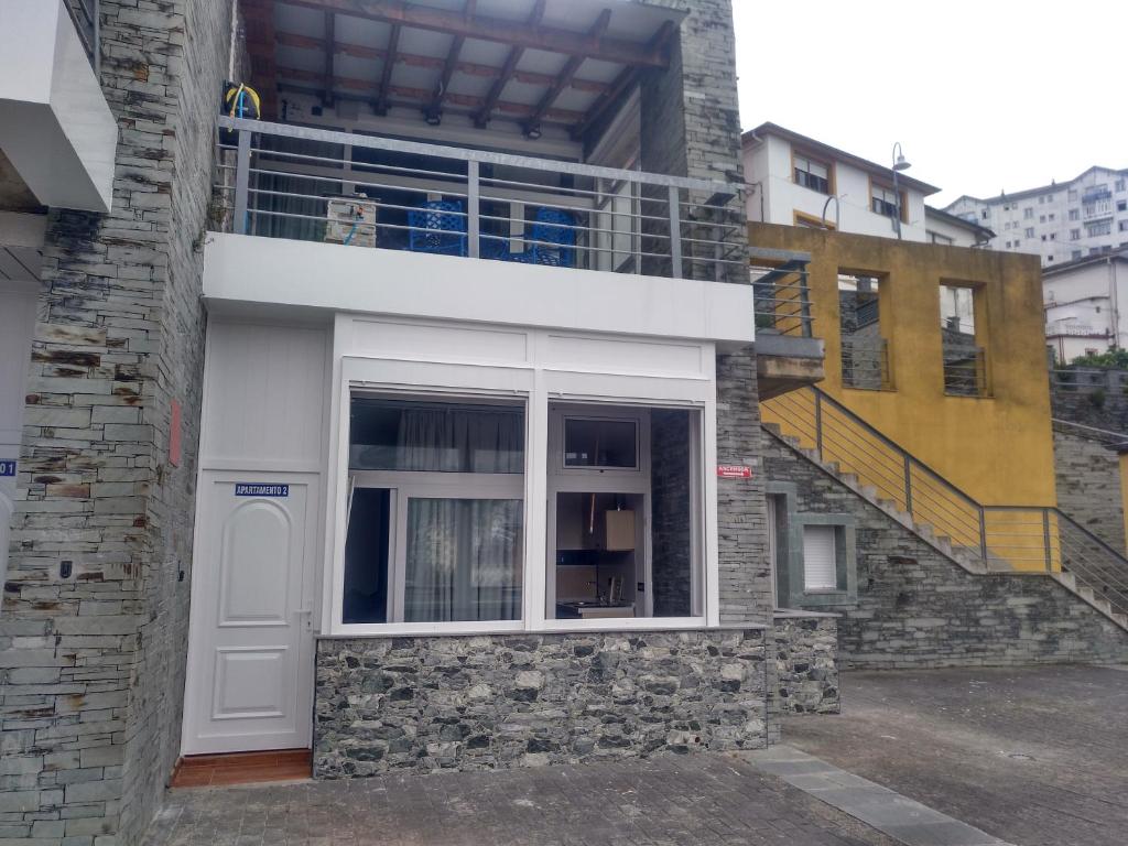 a building with a white door and a balcony at Apartamentos turísticos Vistademar in Luarca