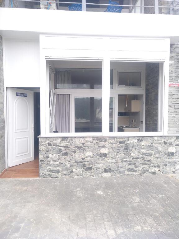 a window on a brick building with a white door at Apartamentos turísticos Vistademar in Luarca