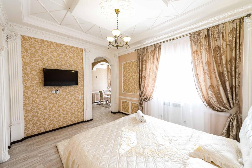 a bedroom with a bed and a tv on a wall at Adler in Astana