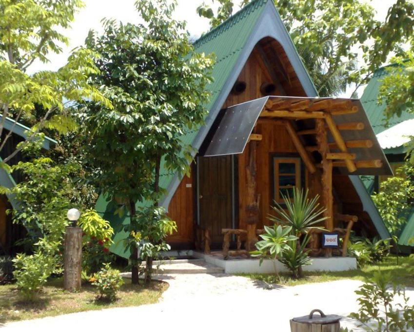 una piccola cabina in legno con tetto verde di MAGMAI HOMESTAY & TOWER a Tak
